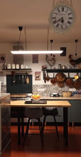 une table dans une cuisine avec une horloge sur le mur dans l'établissement Domaine La Garence, à Villers-sous-Châtillon