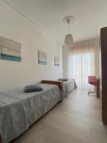 1 dormitorio con 2 camas, escritorio y ventana en Casa Matilde, en Capaccio-Paestum