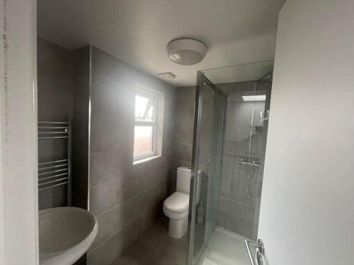 ein Bad mit einer Dusche, einem WC und einem Waschbecken in der Unterkunft 5 Bed, easy access to Stratford/Central London in London