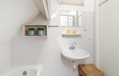 a white bathroom with a sink and a mirror at Oesterbaai -5c2 in Wemeldinge