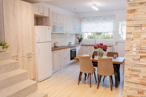 een keuken met een tafel en stoelen en een witte koelkast bij Anastasia's Apartment in Ioannina