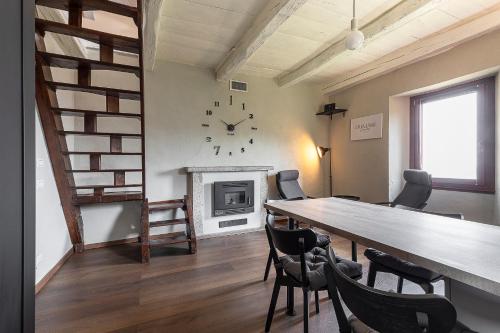 a dining room with a table and a clock on the wall at Casa Belvedere Egro - tiny house in Cesara