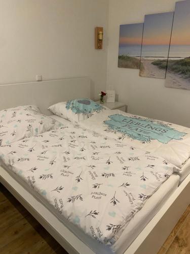 ein Bett mit einer weißen Bettdecke darüber in der Unterkunft Ferienwohnung Lieblingsplatz in Sierksdorf