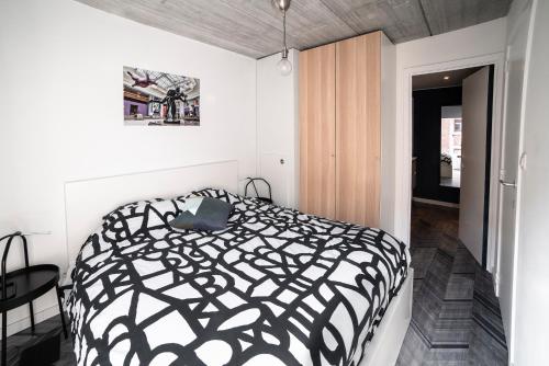 een zwart-wit bed in een witte slaapkamer bij Gîte de Tournai - les beaux-arts in Tournai