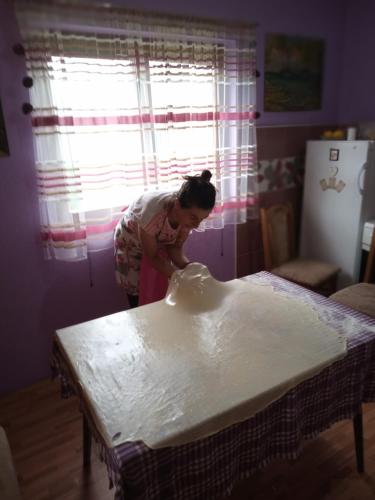 a woman standing over a table with a vase on it at Family owned self sufficient ECO farm TARA in Pljevlja
