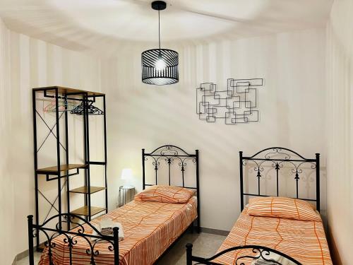 a bedroom with two beds and a chandelier at Attico Giusy in Balestrate