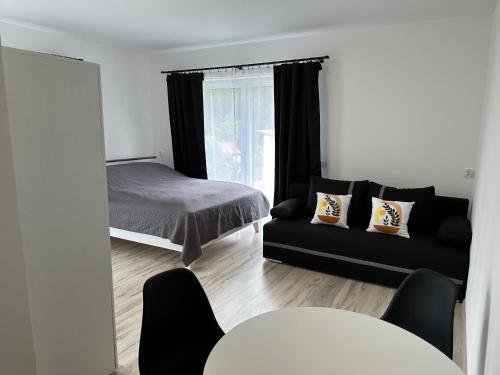 ein Schlafzimmer mit einem Bett, einem Sofa und einem Spiegel in der Unterkunft Roomflacja in Wisła