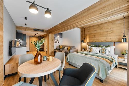 ビャウィ・ドゥナイェツにあるTatra Nest Apartamenty - jacuzzi, sauna!のベッドルーム1室(ベッド1台、テーブル、椅子付)
