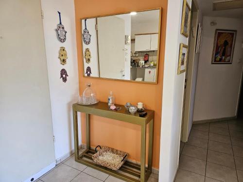 a bathroom with a table and a mirror at Quiet & Comfortable Room in Raanana up to 1 guest in Shared Apartment in Ra‘ananna
