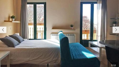 a bedroom with a bed and a table and a chair at Estudio en Centro de Segovia in Segovia