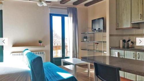 a bedroom with a bed and a kitchen with a table at Estudio en Centro de Segovia in Segovia