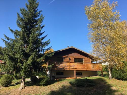 a log cabin with a deck and a tree at Gite de Montagne "Calluna" 1 ou 2 pers in Xonrupt-Longemer