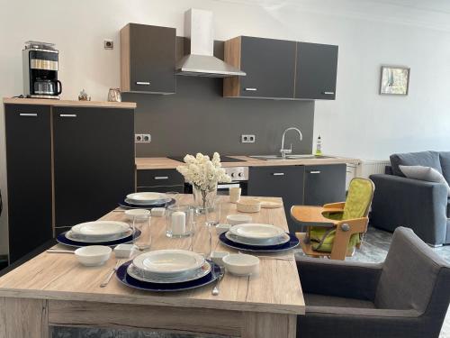 una cocina con una mesa de madera con platos. en Ferienhaus Marktredwitz, en Marktredwitz