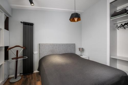 1 dormitorio con 1 cama en una habitación con paredes blancas en Cozy apartment in the center, en Tiflis