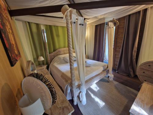 - une chambre avec un lit à baldaquin et un ventilateur dans l'établissement Lodge de Charme 2 Chambres, à Ghisoni