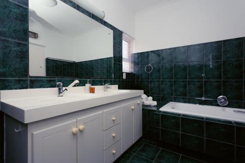 a bathroom with a sink and a mirror and a tub at 49 on Cliff in Gansbaai