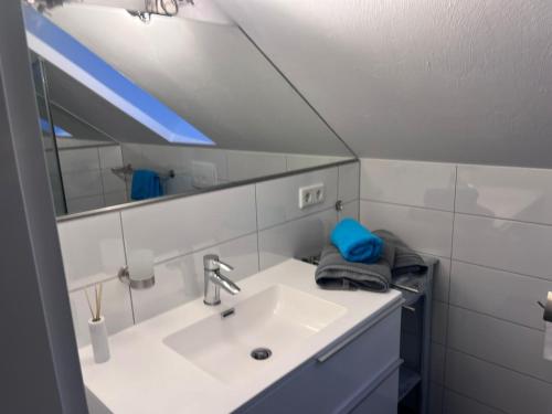 ein Bad mit einem Waschbecken und einem Spiegel in der Unterkunft Willkommen Zuhause - Traumhafte, zentrale Ferienwohnung in Kurstadt in Bad Oeynhausen