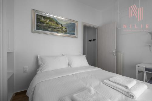 ein weißes Schlafzimmer mit einem Bett mit Handtüchern darauf in der Unterkunft Lusso Bianco, Nilie Hospitality MGMT in Thessaloniki