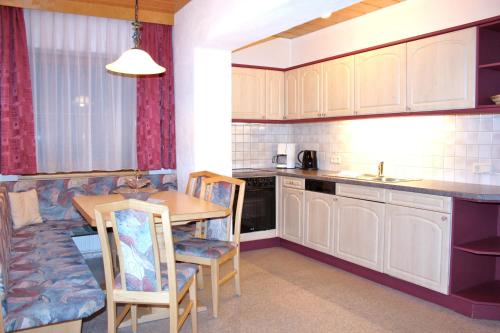 a kitchen with a table and chairs and a counter top at Apart Pfeifer in Ischgl