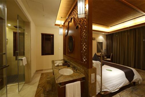 三亚Stony Brook Villa Jianguo Resort Sanya的浴室设有床、水槽和镜子