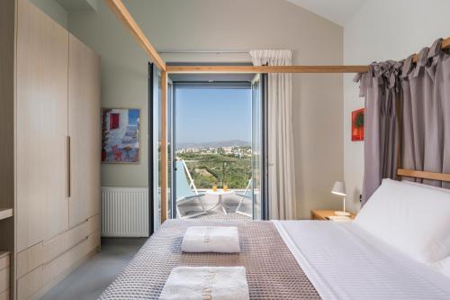 a bedroom with a bed and a large window at Elysium Seaview Oasis in Kato Galatas