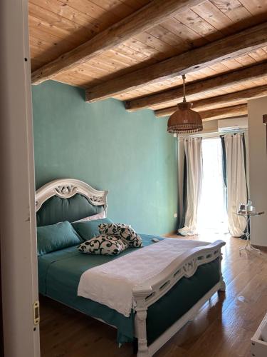 a bedroom with a bed with green walls and a wooden ceiling at B&B Casa CamiLory in San Lucido