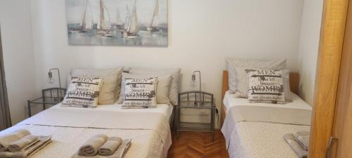 a bedroom with two beds with towels on them at Apartman Campo in Šibenik