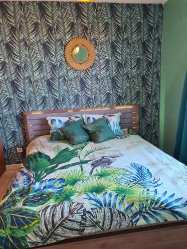 een slaapkamer met een bed met een muur bij Appartement Moderne & Chaleureux in Le Tampon