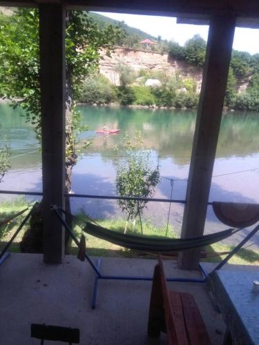 a hammock in a room with a view of a river at Prenoćište na Drini Foča in Foča