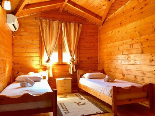 1 Schlafzimmer mit 2 Betten in einem Blockhaus in der Unterkunft Panoramic Vjosa Escapes in Përmet