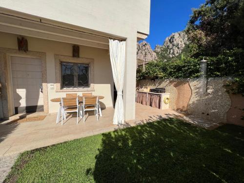 a house with a patio with a table and chairs at Antica Fonte Holiday Homes in San Pantaleo