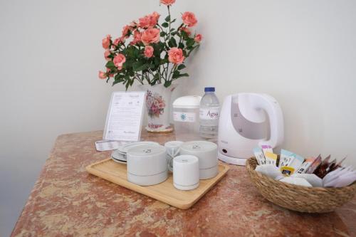 a table with a bunch of cups and a vase with flowers at Quintinha d´Avó in Vila de Prado
