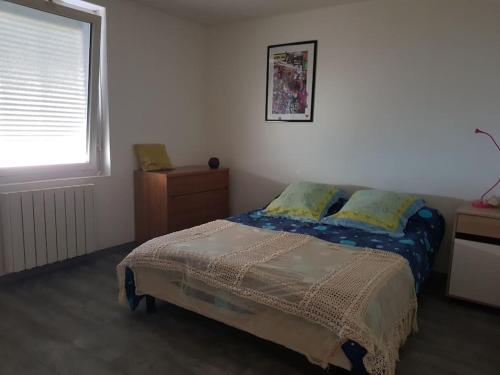 a bedroom with a bed and a window at Appartement RDC avec terrasse in Épinac-les-Mines