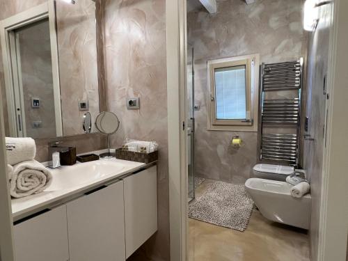 a bathroom with a sink and a toilet and a mirror at Antica Fonte Holiday Homes in San Pantaleo