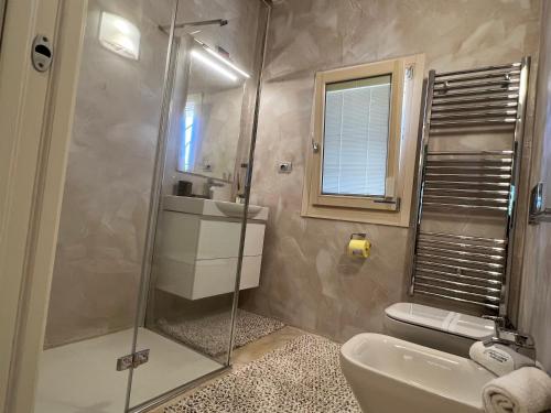 a bathroom with a shower and a sink and a toilet at Antica Fonte Holiday Homes in San Pantaleo