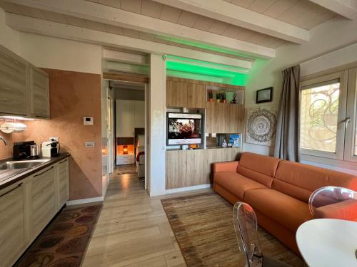 a living room with a couch and a kitchen at Antica Fonte Holiday Homes in San Pantaleo