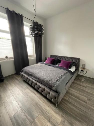 Un dormitorio con una cama grande con almohadas moradas. en Ferienapartment Essen, en Essen