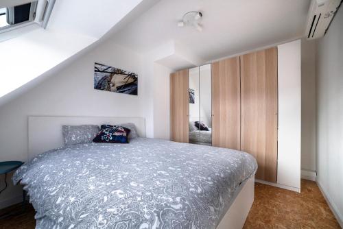 1 dormitorio con 1 cama con edredón gris en Gîte de Tournai-Cathédrale-Centre historique en Tournai
