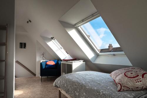 a attic bedroom with a bed and a window at Gîte de Tournai-Cathédrale-Centre historique in Tournai
