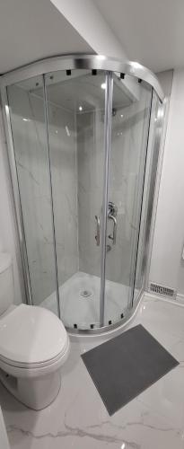 a bathroom with a glass shower with a toilet at Queen Bedroom, Private room, separate entrance 401/404/DVP area in Toronto