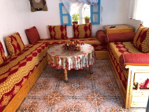 uma sala de estar com um sofá e uma mesa em Casa khadija em Chefchaouen