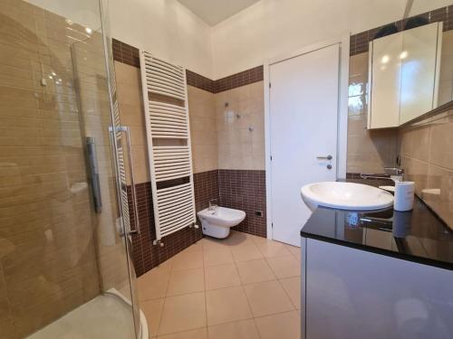 een badkamer met een toilet, een wastafel en een douche bij Villa La Fenice sulle rive del Lago Maggiore in Porto Valtravaglia