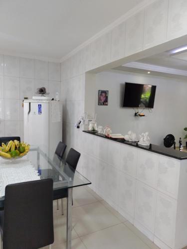 a dining room with a glass table and a refrigerator at casa de temporada em Piranhas ótimo lugar e conforto lila in Piranhas