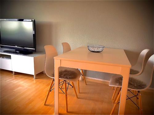 a dining room table with chairs and a television at Ferienhaus Margarete in Gablenz