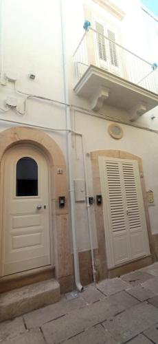 een wit gebouw met een deur en een balkon bij Puglia Holiday Home in Mola di Bari