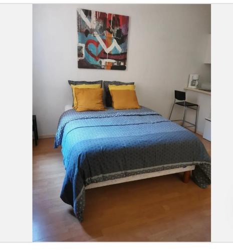 1 dormitorio con 1 cama con 2 almohadas amarillas en Loux en Lyon
