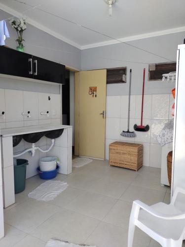 a bathroom with white cabinets and a yellow door at Ótimo lugar e conforto in Piranhas