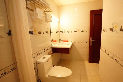 a white bathroom with a toilet and a sink at Thành Vinh Hotel & Apartment in Ho Chi Minh City