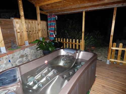 a bath tub in a porch with a wooden deck at La romance. in Prugnanes