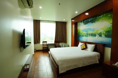a bedroom with a bed and a painting on the wall at Thành Vinh Hotel & Apartment in Ho Chi Minh City